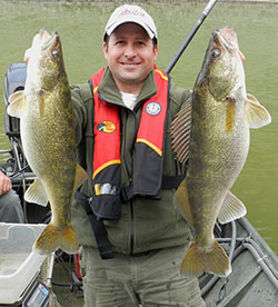 Photo of Ryan Oster Fishing holding two large walleye he caught